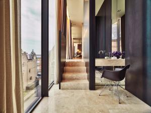 a room with a staircase and a table with a chair at Conservatorium Hotel in Amsterdam
