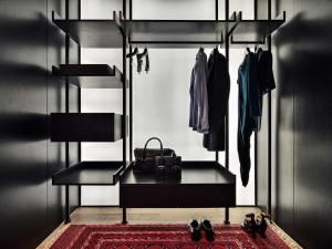 a black room with a shelf with clothes and shoes at Conservatorium Hotel in Amsterdam