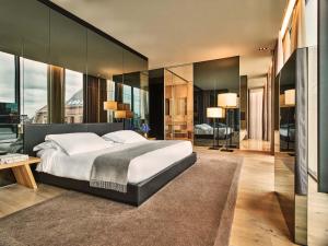 a bedroom with a large bed and glass walls at Conservatorium Hotel in Amsterdam