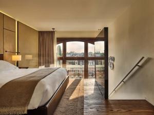 a hotel room with a bed and a large window at Conservatorium Hotel in Amsterdam