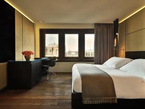 a hotel room with a bed and a desk and window at Conservatorium Hotel in Amsterdam