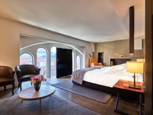 a bedroom with a large bed and a living room at Conservatorium Hotel in Amsterdam