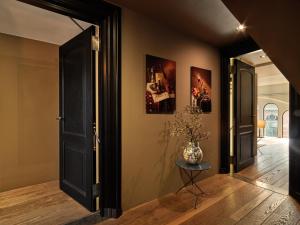 a hallway with a door and a vase on a table at Conservatorium Hotel in Amsterdam