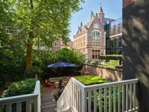 a balcony with a white fence and a garden at Conservatorium Hotel in Amsterdam