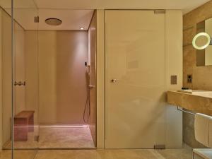 a bathroom with a shower and a glass door at Conservatorium Hotel in Amsterdam
