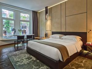 a bedroom with a large bed and a table at Conservatorium Hotel in Amsterdam