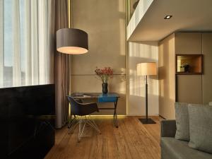 a living room with a table and a lamp at Conservatorium Hotel in Amsterdam