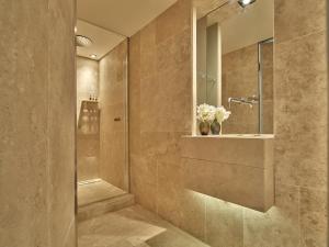 a bathroom with a shower and a vase of flowers at Conservatorium Hotel in Amsterdam