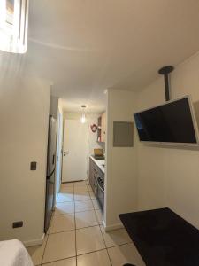 サンティアゴにあるDepartamento Equipado con cocina y WIFI, Excelente Ubicacion cerca del Metroのキッチン(壁に薄型テレビ付)
