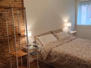 a bedroom with a bed and a brick wall at Casetta don Bosco in Chioggia