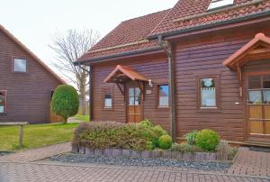 a wooden house with a sign on the front of it at Feriendorf Blauvogel Blauvogel 059 in Hasselfelde