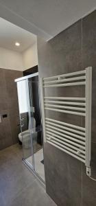 a bathroom with a toilet and a glass shower door at Golden Moon in Lido di Ostia +12 photos