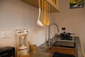 a kitchen with a sink and a stove top oven at Casa Nocodesa in Nicoya