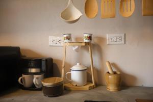 a table with cups on a stand next to a coffee maker at Casa Nocodesa in Nicoya