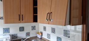 a kitchen with wooden cabinets and tiles on the wall at La casa de Martin in Marchena +42 photos