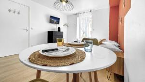 a white table with plates on it in a living room at Studio cosy tout équipé proche de Genève in Viry