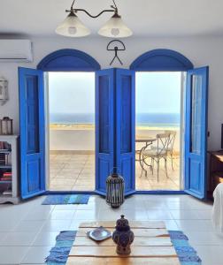 a room with blue doors and a view of the beach at La Atalaya, Terraza con vistas al mediterráneo in Mojácar
