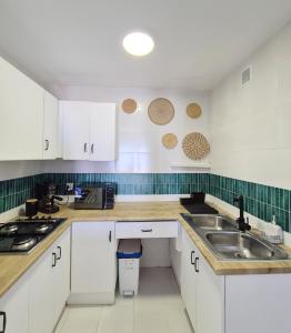 a kitchen with white cabinets and a sink at La Atalaya, Terraza con vistas al mediterráneo in Mojácar +18 photos