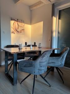 a dining room with a wooden table and chairs at Wood&Stone - Modernes Haus in Seenähe am Tankumsee mit Terrasse, Outdoorküche, Kamin, Homeoffice Bereich & voll ausgestatteter Küche im Naherholungsgebiet in Isenbüttel