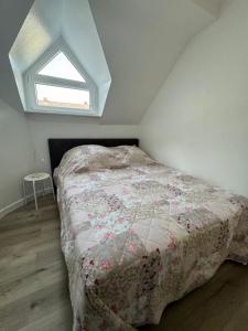 a bedroom with a bed with a quilt and a window at Friedrich Neunzehn in Andernach