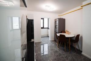 a kitchen and dining room with a table and a refrigerator at Karla's House in Vaslui