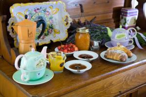 a table with cups and plates of food and drinks at B&B La Torre del Poggio in Poggio