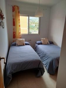 a bedroom with two beds and a window at La Dehesa in Torrox