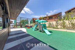 einen Spielplatz mit Rutsche auf einem grünen Rasen in der Unterkunft Beira-Mar, Conforto, Charme e Pé na Areia -Destino BSM 329 in Barra de São Miguel