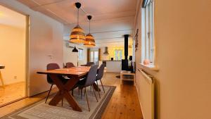 a dining room and kitchen with a table and chairs at Wildlandia Älg Ferienhaus in Hagfors +20 photos