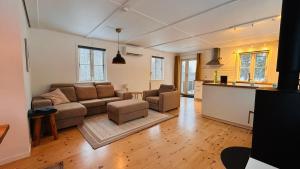 a living room with a couch and a kitchen at Wildlandia Älg Ferienhaus in Hagfors