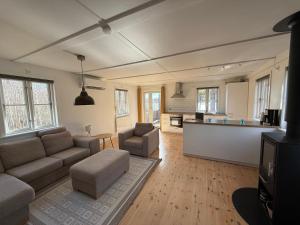 a living room with a couch and a kitchen at Wildlandia Älg Ferienhaus in Hagfors