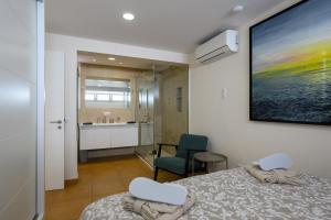 a bedroom with a bed and two chairs and a bathroom at Villa Viña del Mar in Maspalomas +46 photos