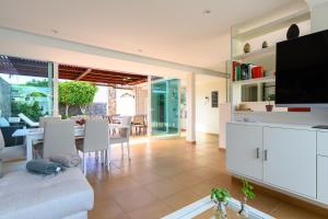 a living room with a couch and a tv at Villa Viña del Mar in Maspalomas