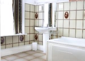 un bagno bianco con lavandino e vasca di Ashley Hotel a Cork