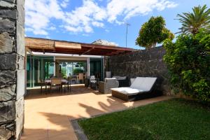a patio with a couch and a stone wall at Villa Viña del Mar in Maspalomas
