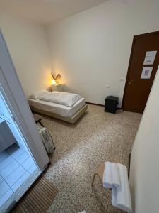 a small bedroom with a bed and a window at Nazìonale Minerbe in Minerbe