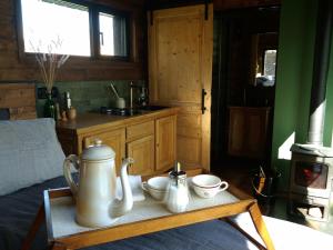 Un dormitorio con una mesa con teteras y tazas encima. en La Tiny House de La Rivière, en Sceaux-du-Gâtinais