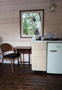 a kitchen with a table and a chair and a window at Roulotte avec terrasse à Montreuil in Montreuil