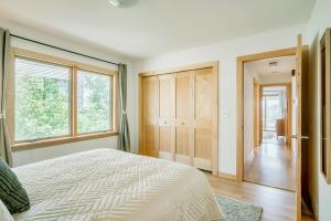 a bedroom with a bed and a large window at Koselig Cottage on Medicine Lake in Minneapolis