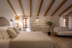 a bedroom with a large white bed and a couch at Old Town Olive luxury room for 3 in Dubrovnik