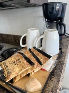 a wooden cutting board with chopsticks and cups on a counter at Flamingo Inn Beachfront - Daytona Beach in Daytona Beach +85 photos