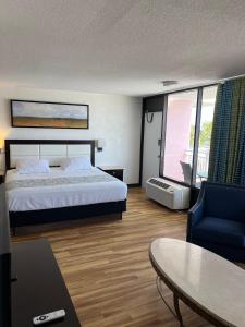 a bedroom with a bed and a table and a chair at Flamingo Inn Beachfront - Daytona Beach in Daytona Beach