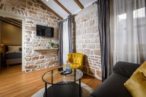 a living room with a glass table and a brick wall at Fenice Palace in Šibenik