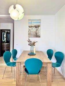 a dining room with a wooden table and blue chairs at Apartments Terra Solaris in Medulin