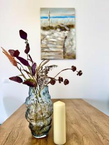 a candle and a vase with flowers on a table at Apartments Terra Solaris in Medulin