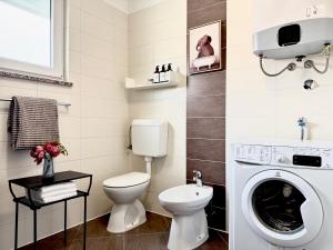 a bathroom with a toilet and a washing machine at Apartments Terra Solaris in Medulin