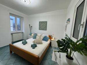 a bedroom with a bed with blue pillows and a plant at Cottage Wisteria Piemonte in Prasco +37 photos