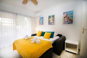 a bedroom with a large bed with yellow sheets at Le Studio Cannois Standing Presta in Cannes +8 photos