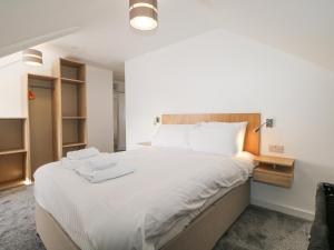 a bedroom with a large bed with two towels on it at Marine Court Three Bedroom Second-floor Apartment 35 in Littlehampton +25 photos