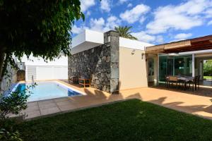 a backyard with a swimming pool and a house at Villa Viña del Mar in Maspalomas